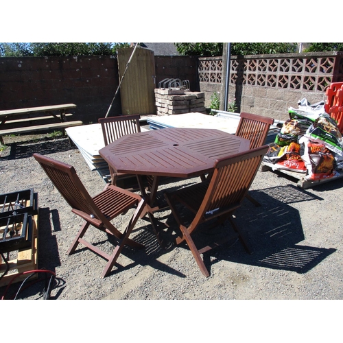 31 - A teak hexagonal patio table together with four matching chairs