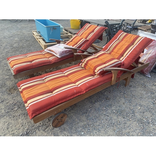 29 - A pair of teak adjustable sun loungers complete with cushions