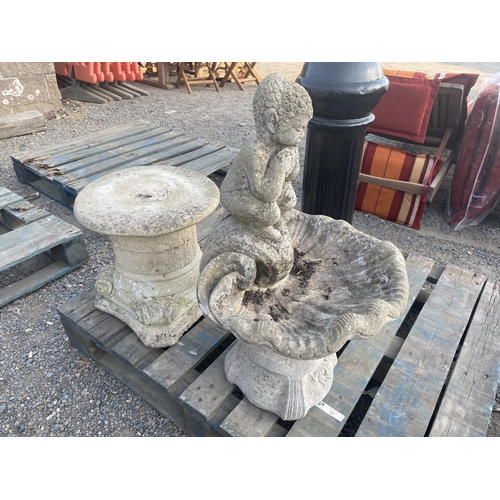 31 - A reconstituted stone garden feature modelled in the form of an elf on a clam shell on pedestal