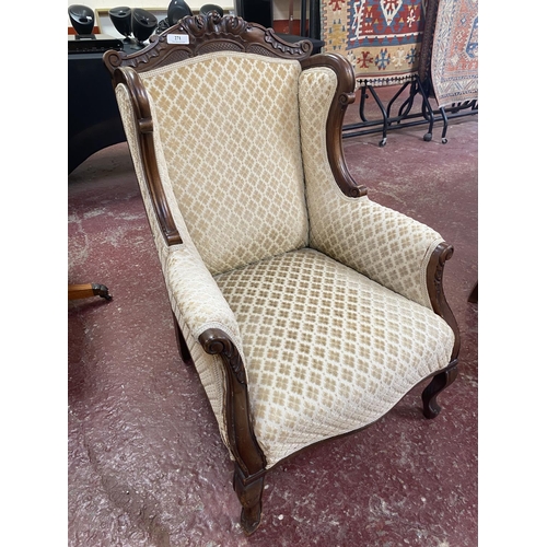 271 - A mahogany wingback armchair upholstered in neutral coloured diamond design fabric