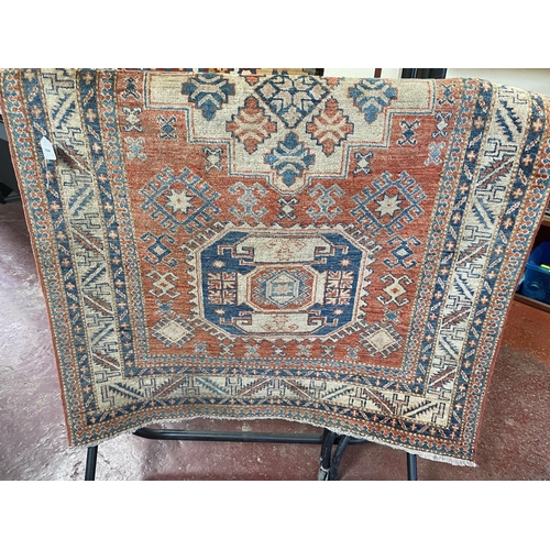 310 - A Pakistani Super Kazak wool floor rug on neutral coloured ground