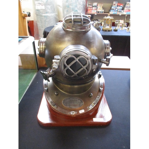 234 - A replica US Navy diving helmet mounted on a wooden plinth