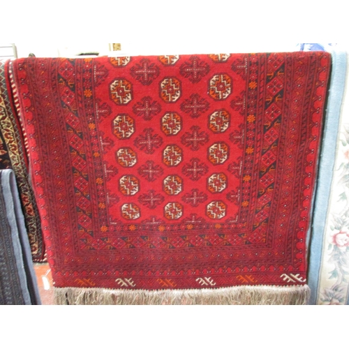 270 - An oriental floor rug with geometric designs on a red ground