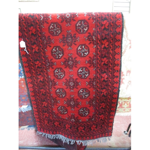 275 - A floor rug with geometric designs on red ground