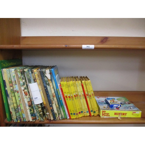 299 - A collection of vintage Rupert the Bear books and jigsaws