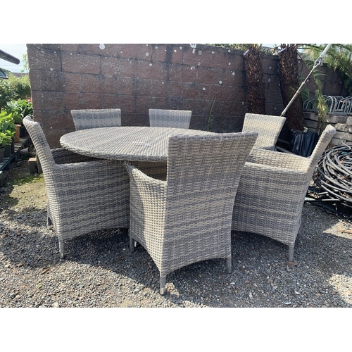 25 - An all weather rattan circular patio table together with six matching chairs