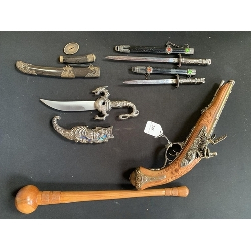 245 - A model of a flintlock pistol together with various knives and daggers of diminutive form and a club