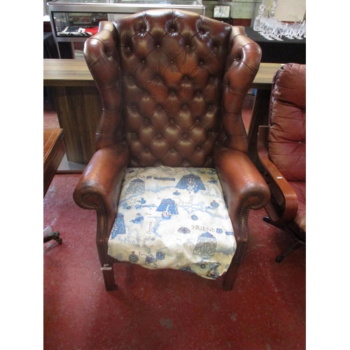 242 - A brown leather wingback armchair