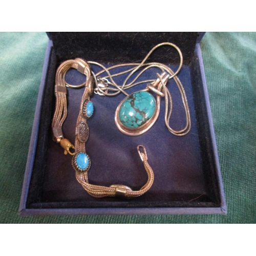 138 - A silver and turquoise pendant on chain together with a silver and turquoise bracelet