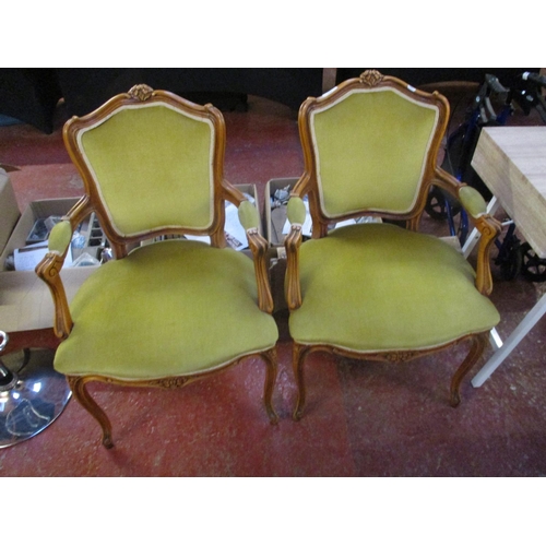 256 - A pair of mahogany open armchairs upholstered in green coloured fabric in the Parisian style