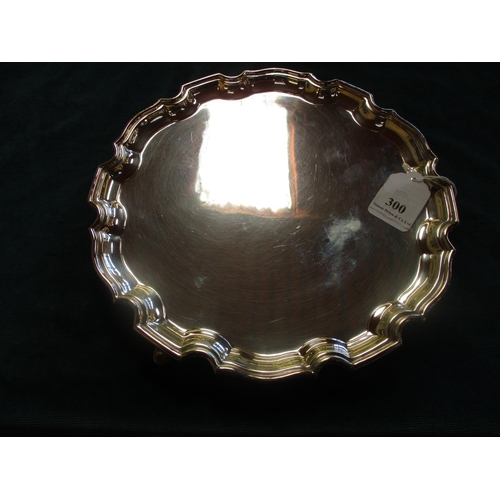 300 - A silver salver set upon three club feet (498 gms)