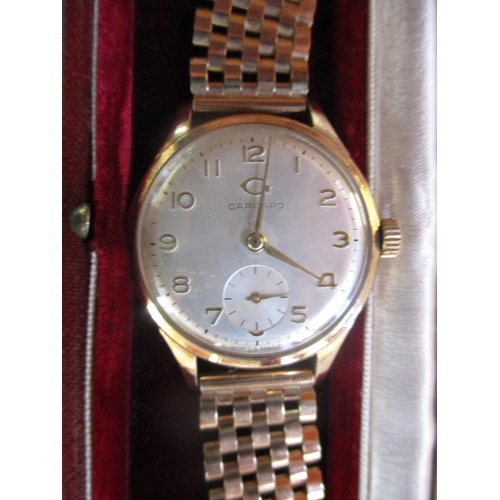 125 - A vintage Garrard 9 carat gold wrist watch on 9 carat gold strap with sub second dial at 6.00 presen... 