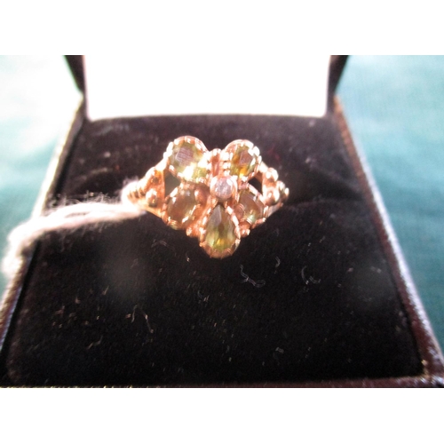 159 - A 9 carat gold dress ring set with peridots and centre diamond (size N)