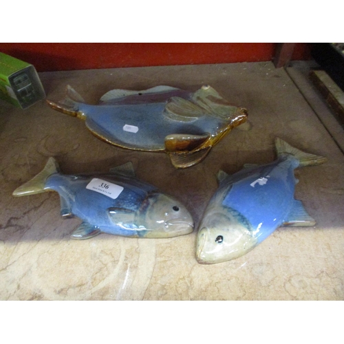 336 - A group of three glazed pottery fish plaques