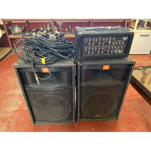 A pair of JBL TR125 professional audio speakers together with amplifier