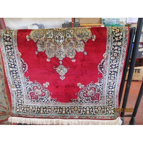 283 - An oriental hand knotted silk floor rug on red coloured ground