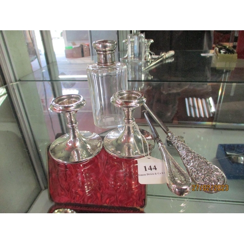 144 - A pair of silver candle sticks of diminutive form, a silver mounted perfume bottle and two silver bu... 