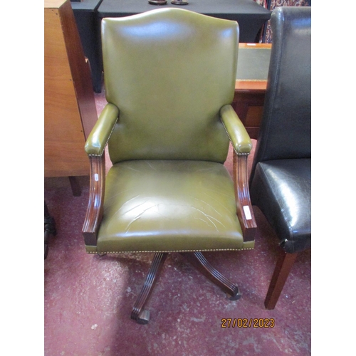 254 - A mahogany revolving study chair upholstered in green coloured leather with applied studded decorati... 