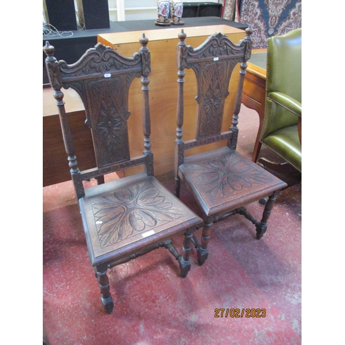 255 - A pair of vintage oak hall chairs with profuse carved decoration