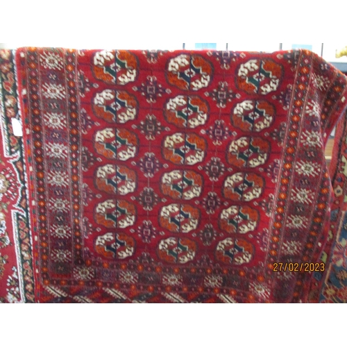 306 - An oriental floor rug on deep red ground with geometric designs