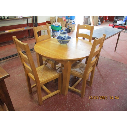 236 - A contemporary solid oak circular extending dining table together with four matching ladder back and... 