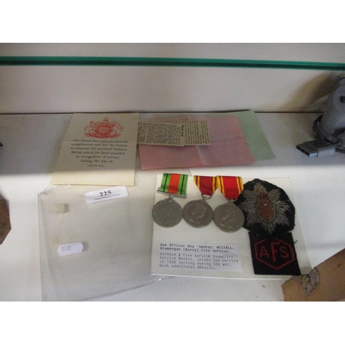 225 - Three Defence and Fire Service Exemplary Service medals together with two uniform badges pertaining ... 