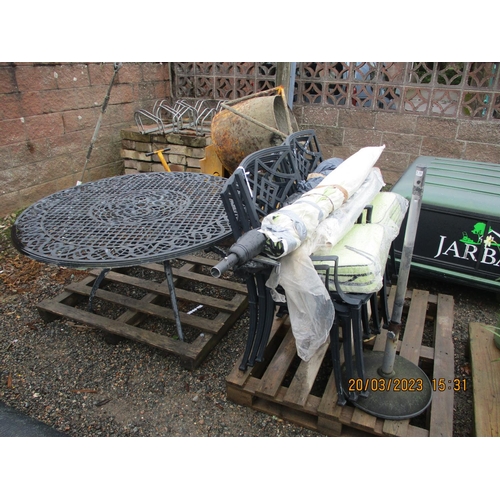 40 - A pierced aluminium circular patio table together with six matching chairs, parasols, base and cushi... 