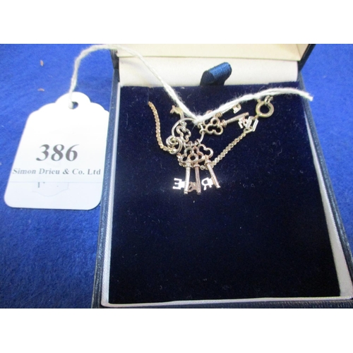 386 - A silver pendant and chains with key charms spelling out JERSEY