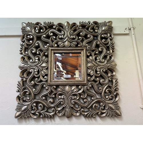 380 - A bevelled glass wall mirror the silver gilt frame of pierced foliate form