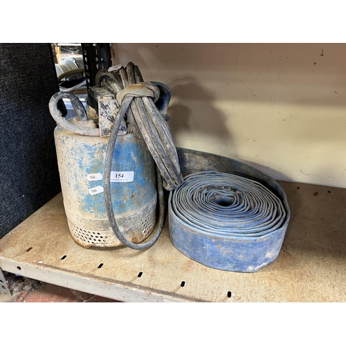 154 - A 110 volt submersible water pump complete with a roll of lay flat delivery hose