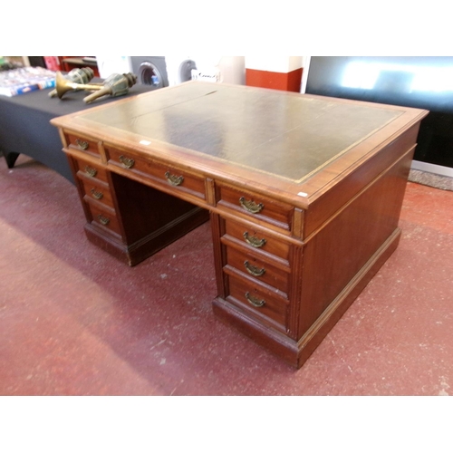 201 - An Edwardian twin pedestal partner's desk the top inlaid with green gilded and tooled leather