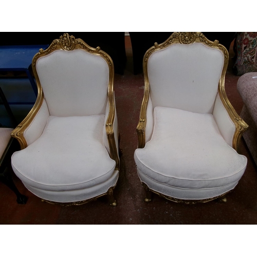 235 - A pair of gilt wood salon armchairs upholstered in neutral coloured foliate design fabric