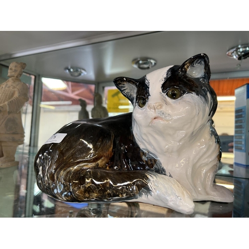 176 - A glazed ceramic model of a reclined cat