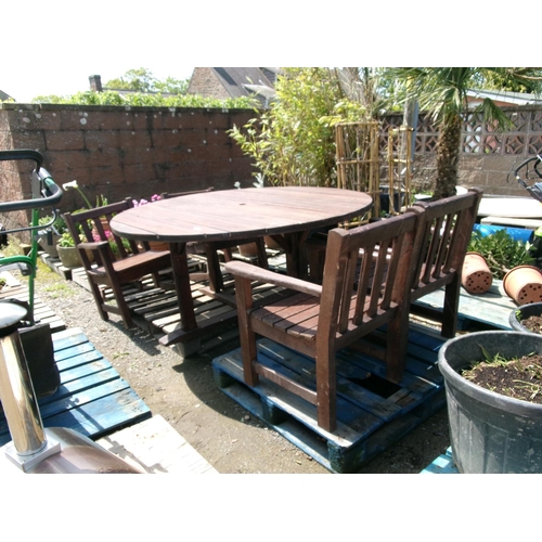 55 - A substantial circular wooden garden table together with four matching chairs