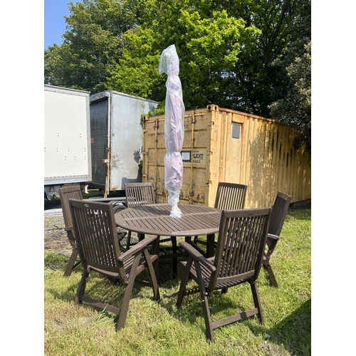 22 - A Hartman teak circular garden table together with six matching chairs, parasol and base