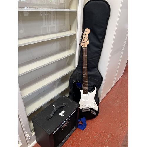 401 - A Squier Strat electric guitar and Peavey amplifier