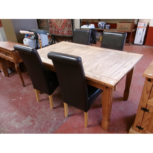 252 - A Mexican Pine dining table together with four chairs fully upholstered in brown coloured leather