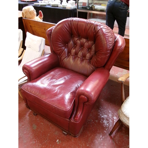 259 - A rocking chair upholstered in red coloured button back leather