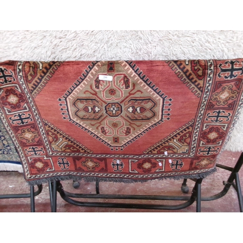 295 - An oriental floor rug decorated with geometric designs on a burnt red coloured ground