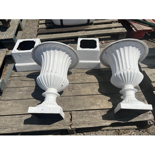 63 - A pair of cast iron stemmed garden urns on plinths