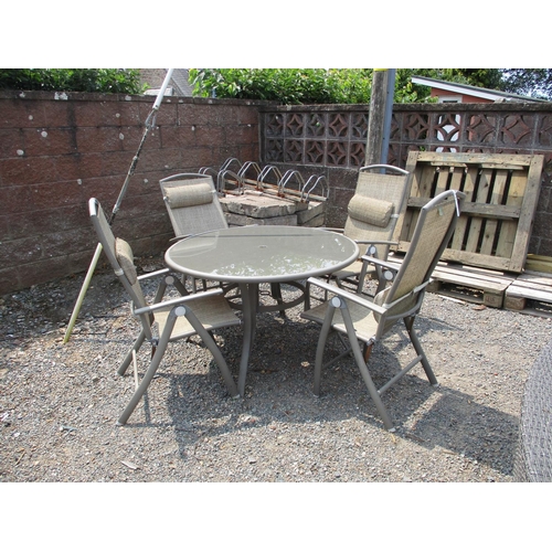 32 - A metallic circular glass top patio table together with four matching chairs