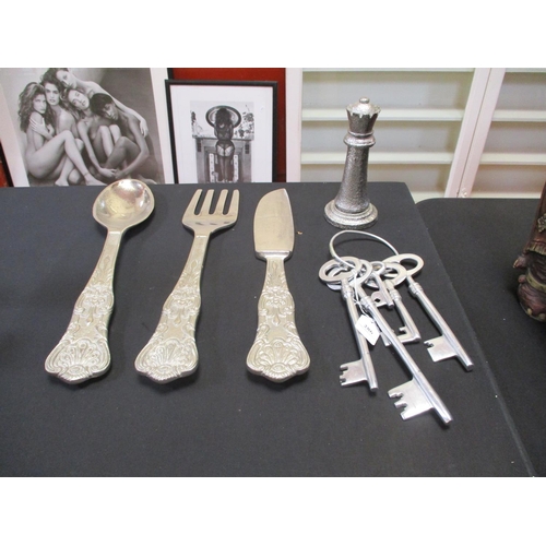 A knife, a spoon and a fork of gigantic proportion together with a set