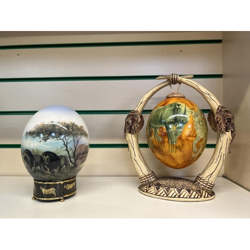 197 - Five Ostrich eggs with intricate painted decoration, three suspended from simulated animal horn