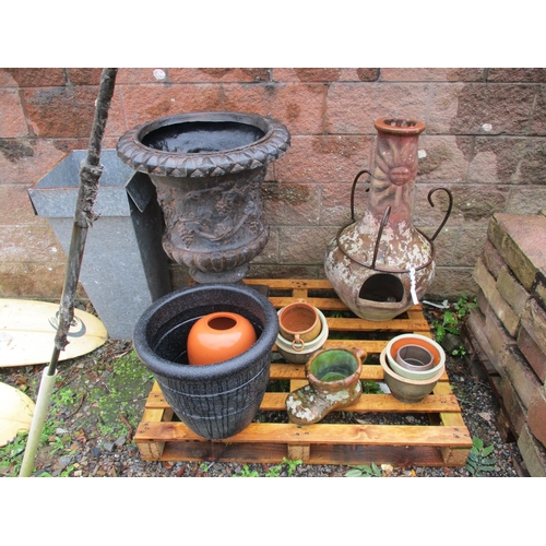 39 - A terracotta chiminea on wrought metal base together with various planters