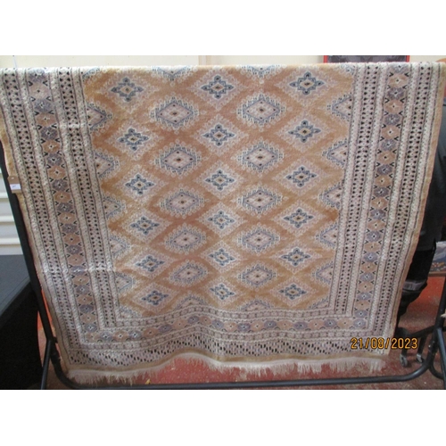 287 - An oriental silk floor rug decorated with geometric designs on a pale pink ground