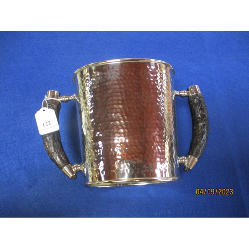 122 - A silver plated twin handled ice bucket with hammered decoration