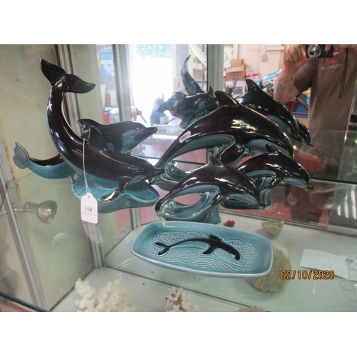 158 - Four Poole Pottery dolphin models together with a similar dish