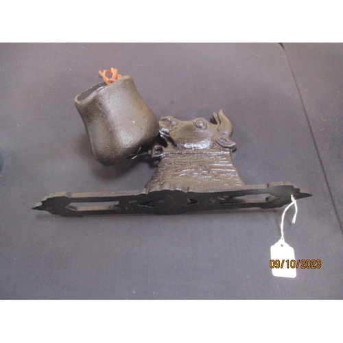 287 - A cast iron wall mounted bell modelled in the form of a cow and bell