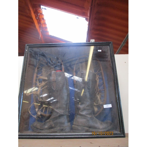 111 - A glazed display cabinet containing a pair of vintage leather boots and snow shoes
