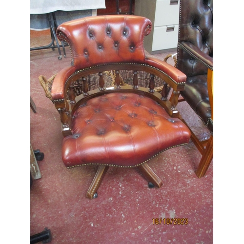 254 - A mahogany framed revolving office chair upholstered in brown button back leather